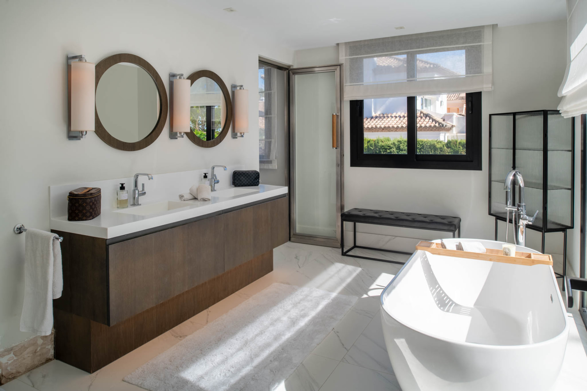 A bathroom with a double vanity and a freestanding bath.