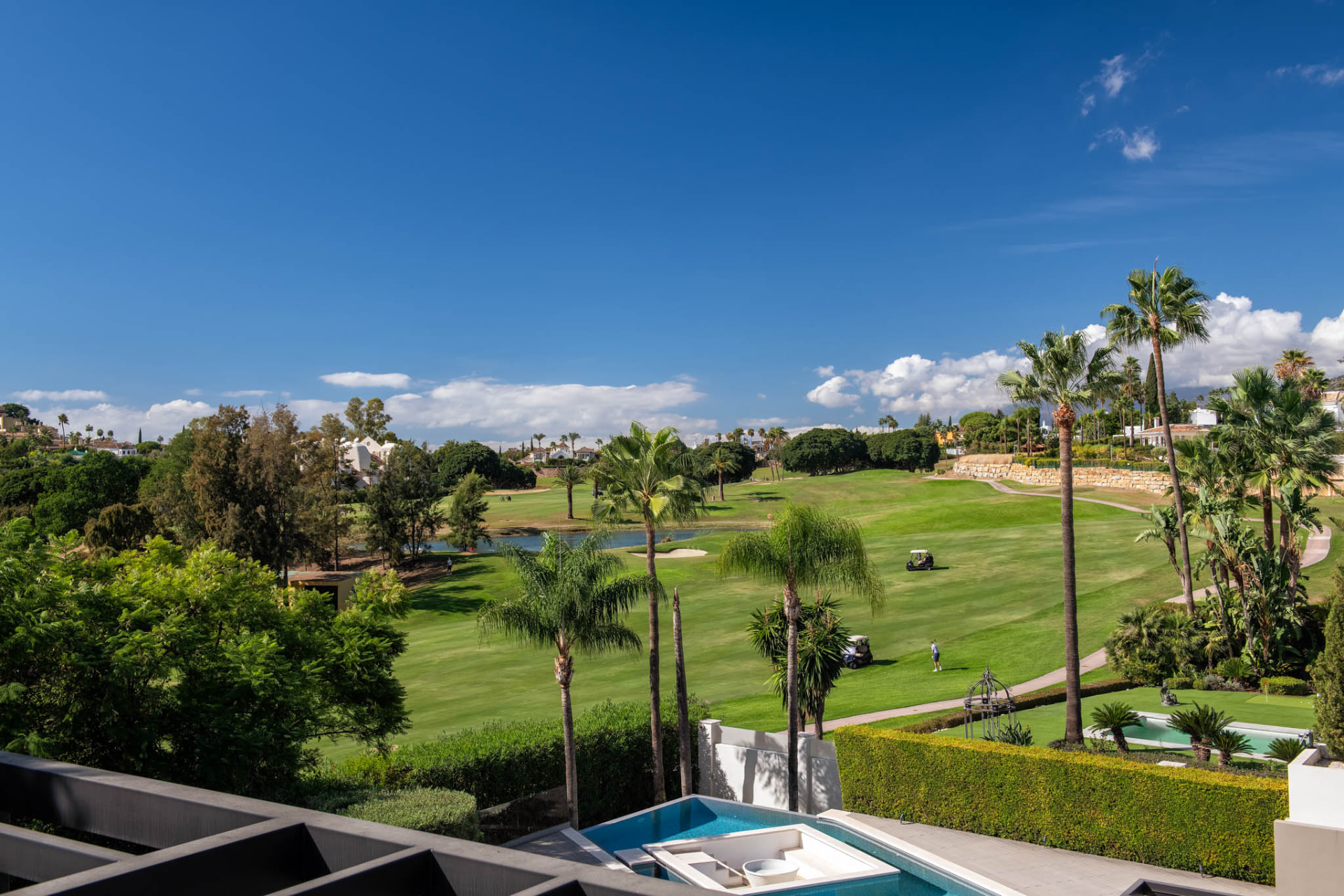 View across the green golf landscape with its water feature, seen from the property.