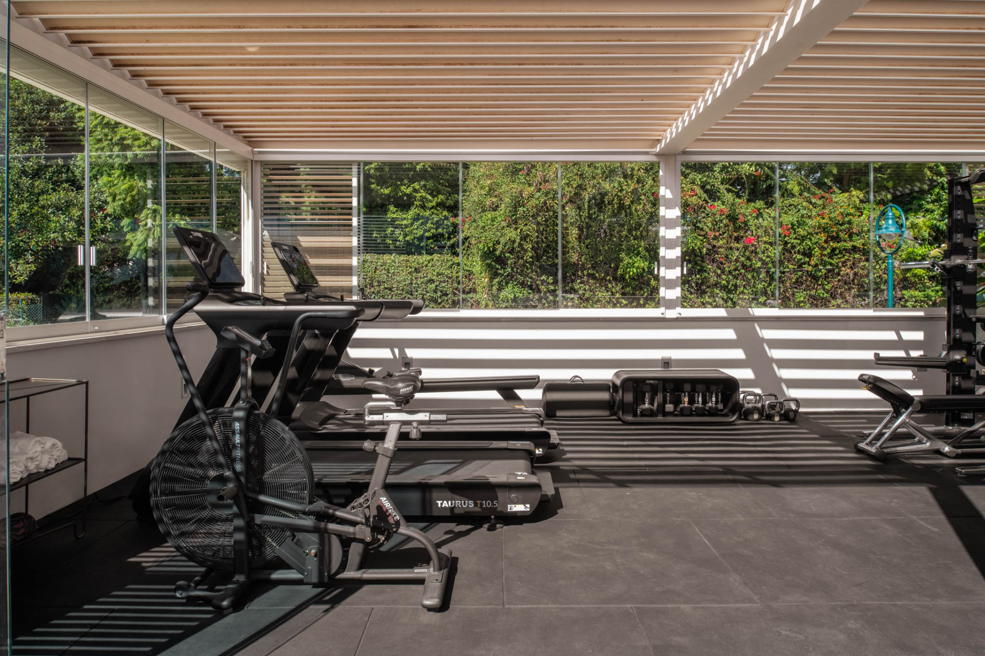 The gym with broad glazing looking out to the garden greenery.